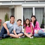 Happy family relaxing in backyard of new home